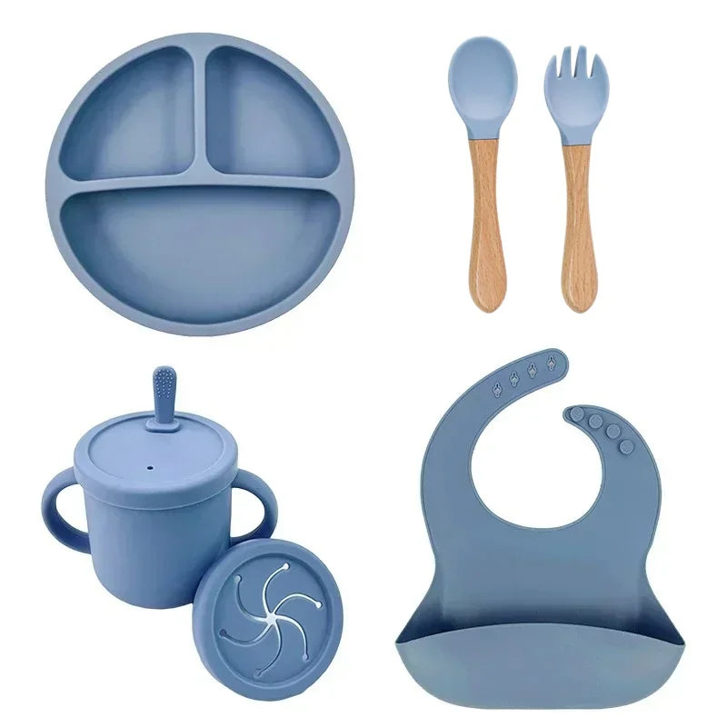Blue silicone baby feeding set with divided plate, bib, sippy cup, spoon, and fork.