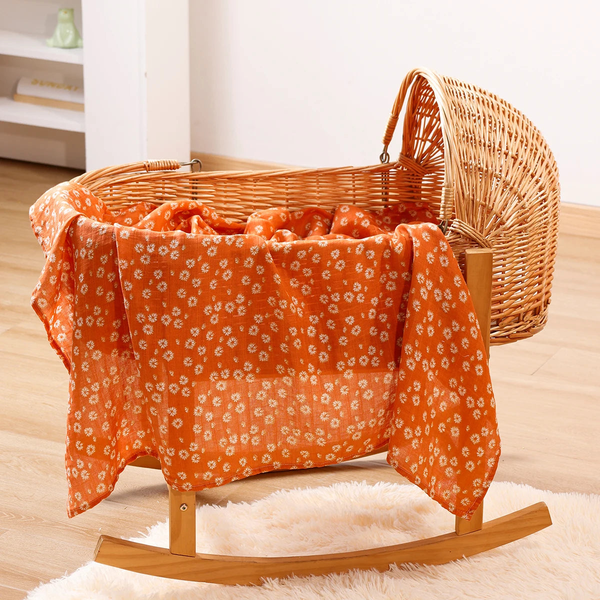 Wicker bassinet with orange floral baby blanket in cozy nursery setting
