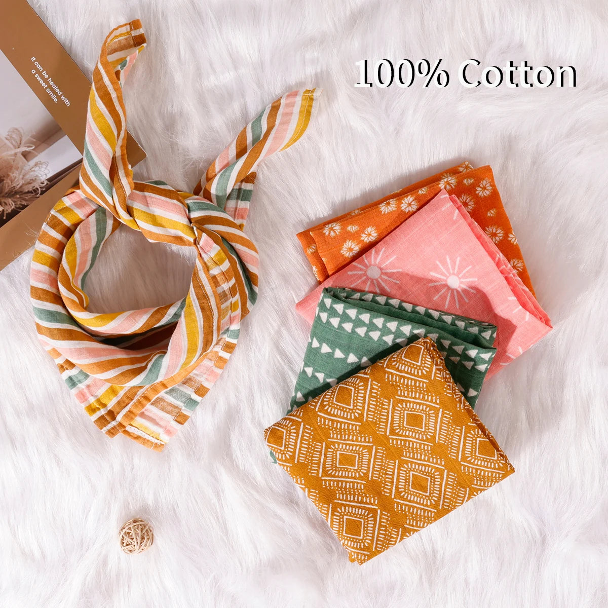 Colorful 100% cotton baby muslin cloths with geometric and floral patterns on a soft white surface