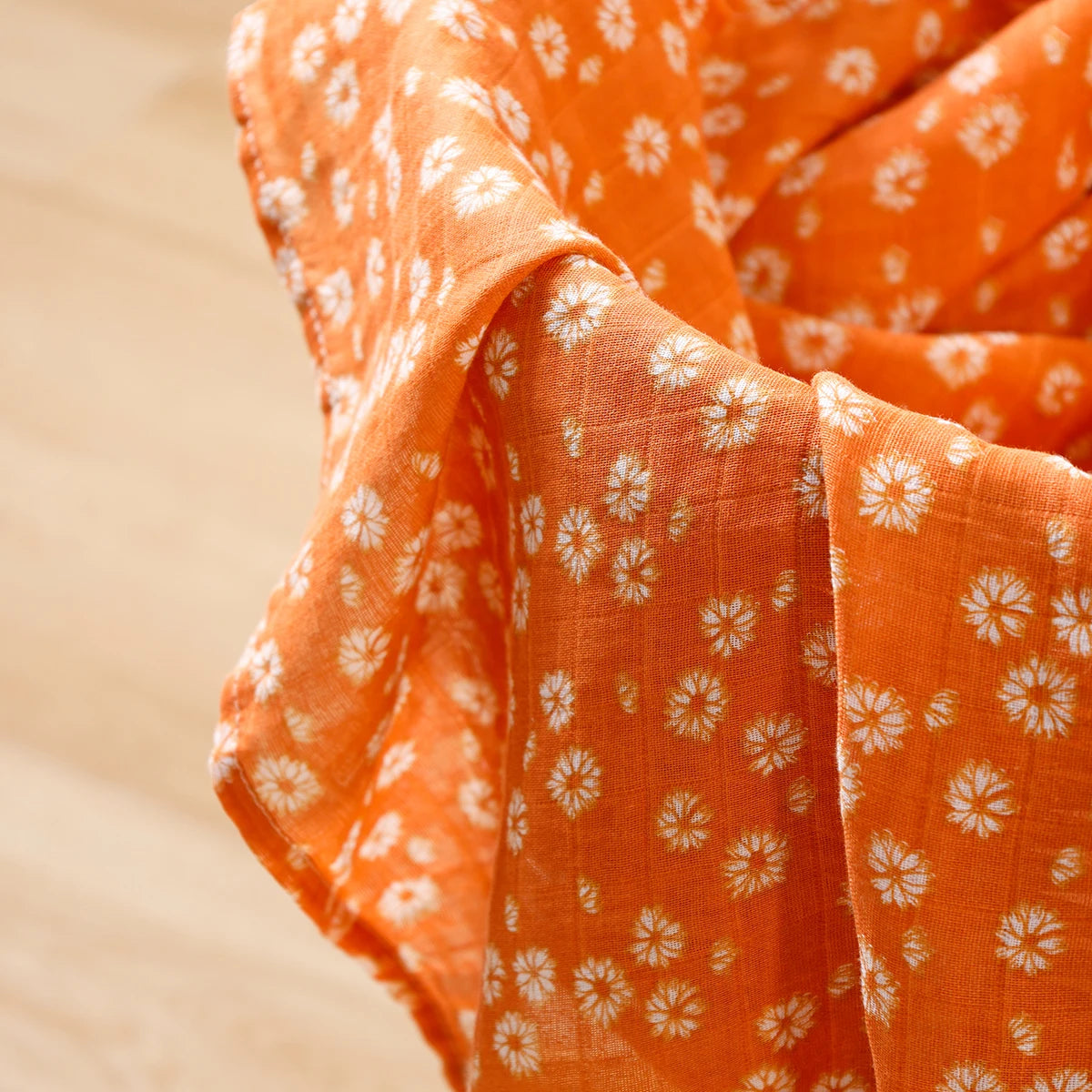 Soft orange muslin baby blanket with white daisy floral print pattern