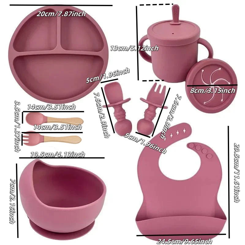 Pink baby feeding set with silicone plate, bowl, bib, sippy cup, utensils, and measurements.