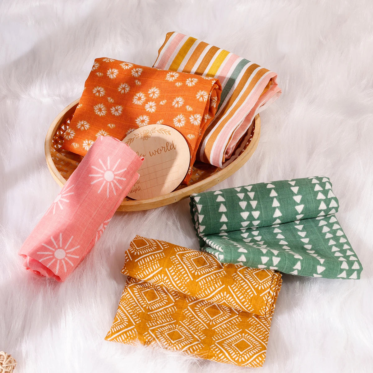 Colorful cotton baby swaddles with geometric and floral patterns on soft white fur